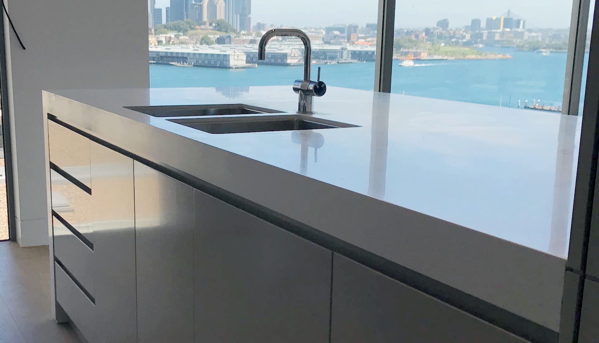 Minimalist kitchen design with handleless cabinets and white waterfall island Milsons Point